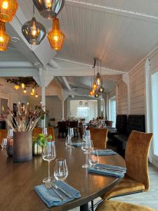 una sala da pranzo con tavolo e bicchieri da vino di Penthouse Leilighet TorskenSenteret a Torsken