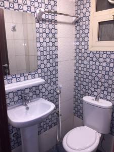 a bathroom with a white toilet and a sink at FURNISHED BEDROOM APARTMENT IN NAZIR PLAZA in Ajman 