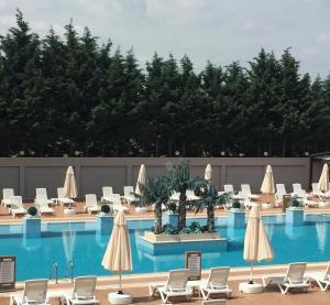 a large swimming pool with chairs and umbrellas at Hotel Yayoba in Tekirdağ