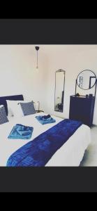 een slaapkamer met een groot bed met blauwe lakens en een spiegel bij בלקוני לחוף דור in Dor