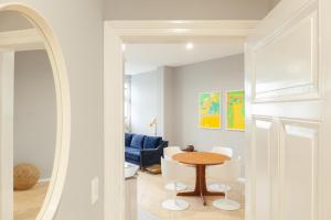 a dining room with a table and white chairs at OSTKÜSTE - Kaiser Karl Design Apartments in Heringsdorf