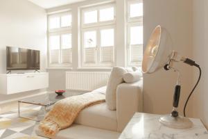 a living room with a couch and a lamp at OSTKÜSTE - Kaiser Karl Design Apartments in Heringsdorf