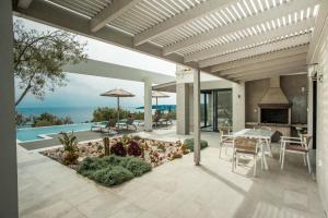 an outdoor patio with a table and a fireplace at Premium Ionian Villas - Vlachata in Vlachata