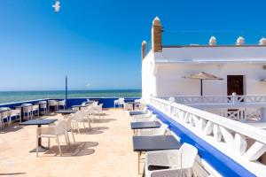 a row of tables and chairs on a balcony overlooking the ocean at Palais Des Remparts in Essaouira