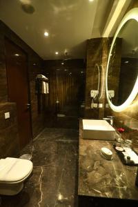 a bathroom with a toilet and a sink and a mirror at Stardom Resort Jaipur in Jaipur