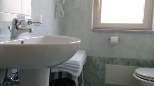 a bathroom with a sink and a toilet and a window at B&B Capo Sant'Alessio in SantʼAlessio Siculo