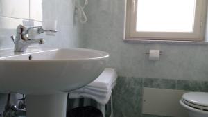 a bathroom with a sink and a toilet and a window at B&B Capo Sant'Alessio in SantʼAlessio Siculo