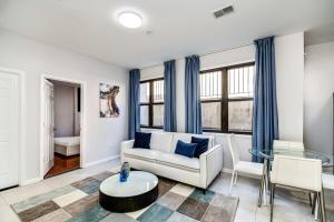 ein Wohnzimmer mit einem weißen Sofa und einem Glastisch in der Unterkunft The blue wall 2BD apartment with excellent location in Philadelphia