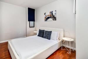 a white bedroom with a white bed and a table at The blue wall 2BD apartment with excellent location in Philadelphia