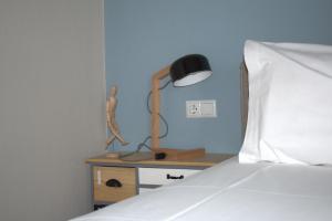 a bedroom with a bed and a lamp on a night stand at Zaza Home in Kavála
