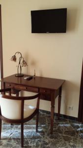 a wooden desk with a chair and a television on a wall at B&B Capo Sant'Alessio in SantʼAlessio Siculo