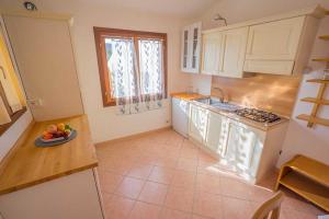 a kitchen with a plate of fruit on the counter at residence baia sant anna con piscina in Tanaunella +58 photos