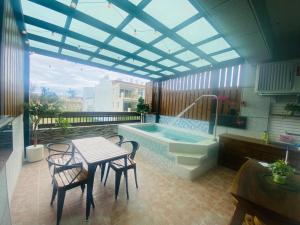 patio con tavolo e vasca da bagno di 墾丁涵寓包棟民宿 a Città Vecchia di Hengchun