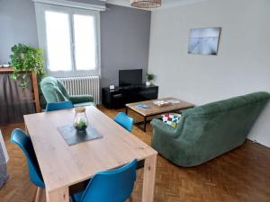 - un salon avec une table et des chaises en bois dans l'établissement Appartement dans Villa, à Pau
