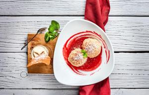 un piatto bianco con un dessert rosso su un tavolo di Gasthaus Wundsam a Neustift im Mühlkreis