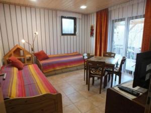 een slaapkamer met 2 bedden, een tafel en een bureau bij Haus Schipper am Wald in Gemünden