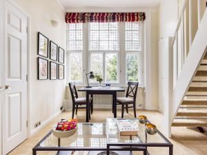 a living room with a table and chairs and a window at Pass the Keys Cosy studio flat by Thames river in Chelsea in London