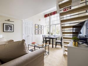 a living room with a staircase and a table at Pass the Keys Cosy studio flat by Thames river in Chelsea in London