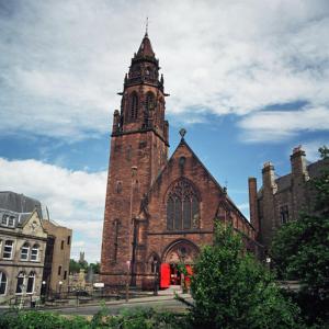 a large brick building with a clock tower on it at Belford Hostel in Edinburgh