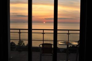 a view of the ocean at sunset from a balcony at Promenada28pl - Apartamenty z widokiem na morze in Międzyzdroje