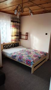 a bedroom with a bed with a colorful quilt on it at U Tosi in Czorsztyn