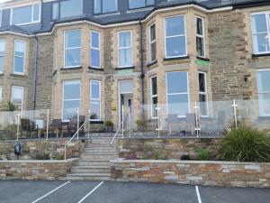 an empty parking lot in front of a brick building at Geckos Rest in Newquay +60 photos