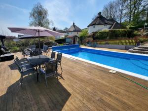 a patio with a table and umbrella next to a pool at St Andrews House B&B in Lyme Regis