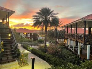 un complejo con una palmera y una puesta de sol en Blue Bay BEACH Villa 27 3-min beach-pool-golf, en Blue Bay