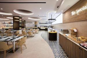 un restaurante con mesas y sillas y una cafetería en Hotel Gold Arcos 4 Sup - Built in May 2022, en Benidorm