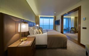 a hotel room with a bed and a table with a lamp at Les Suites at The Cliff Bay - PortoBay in Funchal