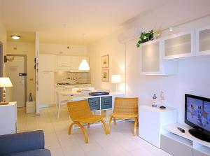 a living room with a couch and a tv and a kitchen at Apartment Pine Wood in Bibione