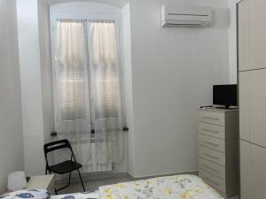 ラ・スペツィアにあるCasa Cristina e Mauroのベッドと椅子と窓のある寝室