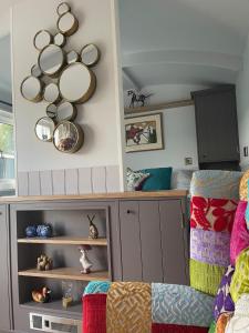 a room with a couch and some plates on the wall at 'The Barrington' - Westwell Downs Shepherd Huts in Burford