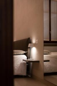 a bedroom with a bed and a table with a lamp at ROMA PREMIUM in Casale Monferrato