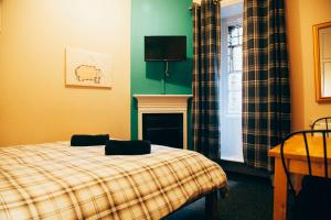 a bedroom with a bed with a fireplace and a television at Belford Hostel in Edinburgh