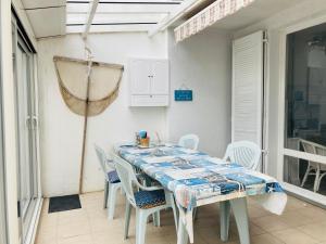 uma mesa branca e cadeiras num quarto em Maison des loriots, charme marin, plage à 100m em Saint-Jean-de-Monts