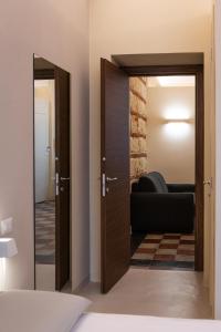 a room with two open doors and a couch at ROMA PREMIUM in Casale Monferrato