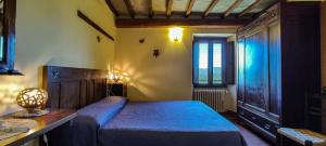 パラッツオーロ・スル・セーニオにあるAgriturismo I Monti di Salecchioのベッドルーム1室(ベッド1台、テーブル、窓付)
