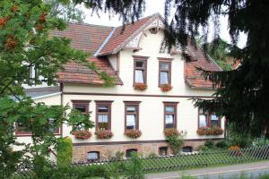 une maison blanche avec des boîtes de fleurs sur elle dans l'établissement Haus am Kurpark, à Sankt-Andreasberg