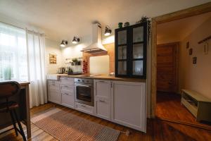a kitchen with white cabinets and a stove at Pils Parka Apartamenti in Kuldīga