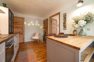 a kitchen with a counter top with a vase of flowers at Pils Parka Apartamenti in Kuldīga