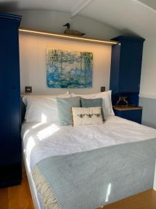 a bedroom with a large white bed with blue cabinets at The Bibury - Westwell Downs Shepherd Huts in Oxford