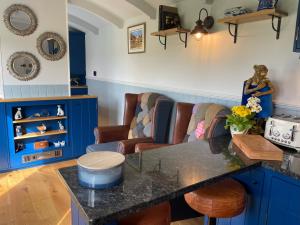 a kitchen with blue cabinets and a counter top at The Bibury - Westwell Downs Shepherd Huts in Oxford