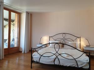 een slaapkamer met een bed met een smeedijzeren hoofdeinde bij Maison des pêcheurs vue lac a 50m du port dans quartier historique in Thonon-les-Bains