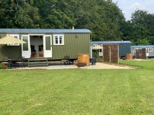 a green and white tiny house in a yard at The Bibury - Westwell Downs Shepherd Huts in Oxford