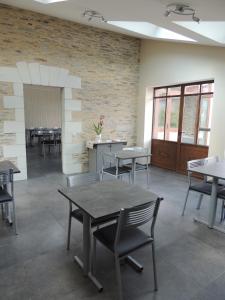 a dining room with tables and chairs and a brick wall at Les Chambres du Meunier in Juigné-sur-Loire