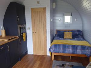 um quarto com uma cama com um edredão azul e amarelo em Honeypot Hideaways Luxury Glamping - Exclusively for Adults em Chester