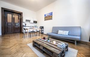 salon z niebieską kanapą i stołem w obiekcie Legerova Apartments w Pradze