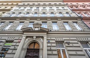 wysoki budynek z zegarem na górze w obiekcie Legerova Apartments w Pradze