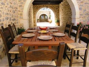 uma mesa de madeira e cadeiras num quarto com uma mesa e uma espreguiçadeira em Litiniana Villas em Triopetra